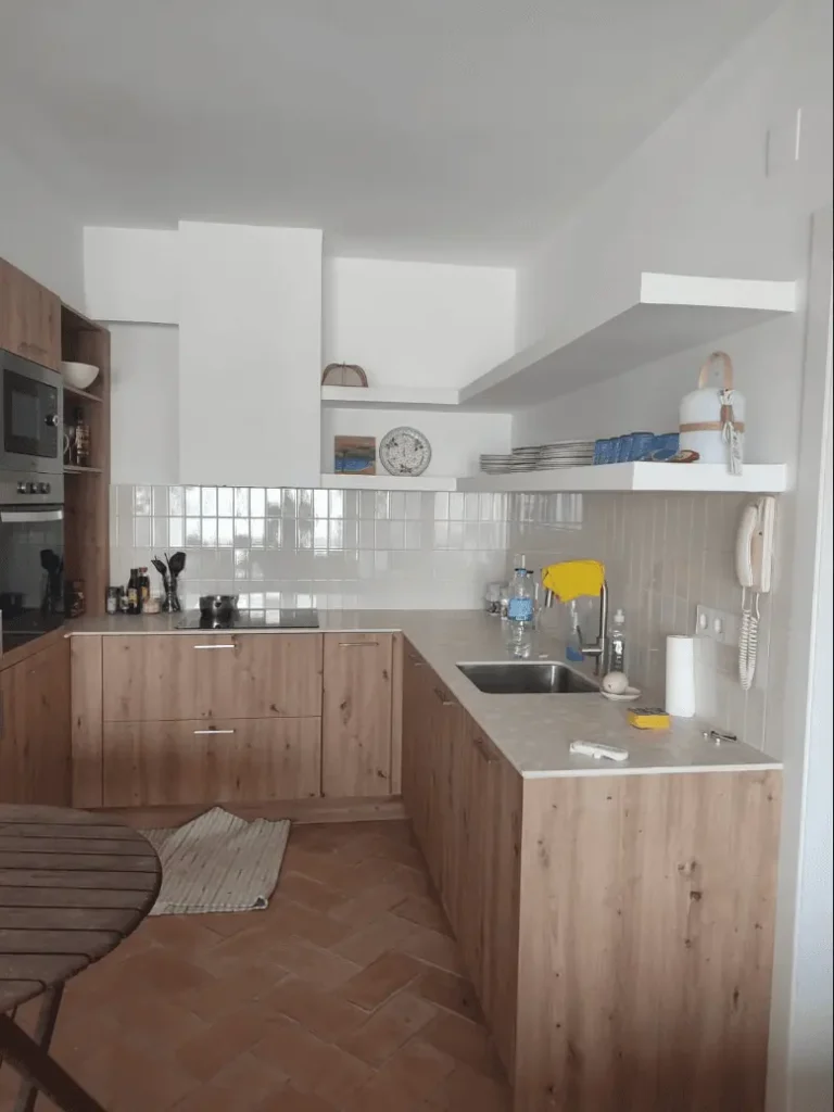Reforma de cocina rústica en Calella de Palafrugell con suelo cerámico en espiga y mobiliario efecto madera