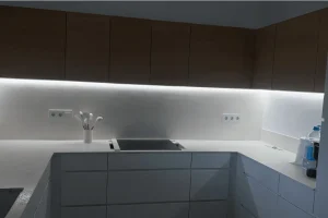 Iluminación LED lineal en cocina blanca con mobiliario lacado y armarios de madera