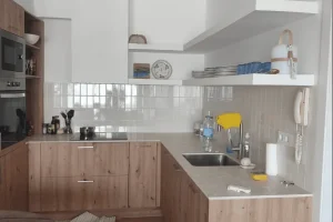 Reforma de cocina rústica en Calella de Palafrugell con suelo cerámico en espiga y mobiliario efecto madera